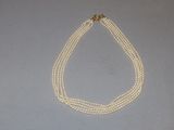 three strand pearl necklace with a gold clasp and clasp