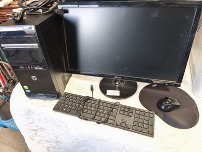 un ordinateur de bureau posé sur une table, équipé d'un clavier et d'une souris