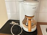 a coffee maker on a kitchen counter with a cord plugged in