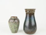two vases sitting next to each other on a white surface
