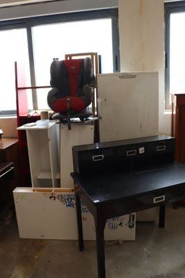 a black desk in a room with a lot of boxes on the floor