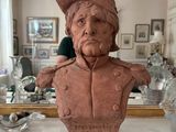 a bust of a man with a hat on a table