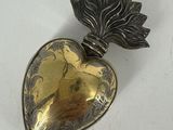 un fermoir en forme de cœur, en argent et en or, orné d'une feuille