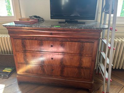 a tv on a dresser with a ladder in front of it