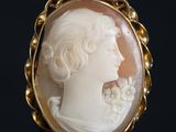 an antique carved shell cameo of a woman with flowers in her hair