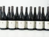 six bouteilles de vin sont alignées sur une table