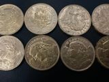 six different british coins are shown in a row on a black surface