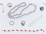 several different types of necklaces and rings on a white surface