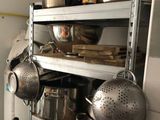 a shelf with pots and pans on it in a kitchen