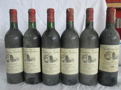 six bouteilles de vin rouge sont alignées sur une table