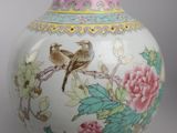 two birds sitting on a branch of a tree in a vase