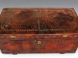 an old leather box with a decorative design on the lid