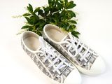 grey and white sneakers with white laces on a white surface