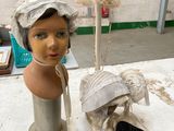 une tête de mannequin et une paire de chaussures posées sur une table