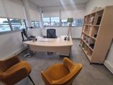 an image of an office with a desk, chair and bookshelf