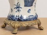 a blue and white vase on a stand on a table