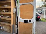 a white van with a wooden door and shelves in the back of it