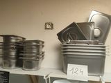 many pots and pans on the shelf in the kitchen