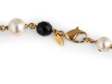 an image of a gold chain with pearls and a black and white bead