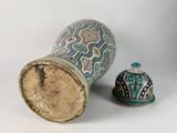 a vase and a bell sitting on a white surface