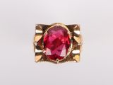 a close up of a red stone ring on a white surface