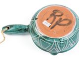 a tea pot with a handle and a tag on it