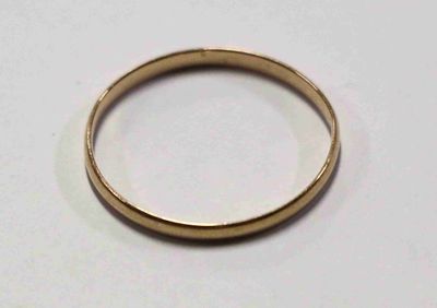 une image d'un gros plan d'une bague en or sur une surface blanche
