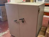 une armoire blanche dans un entrepôt, avec des cartons par terre