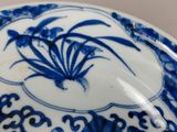 a blue and white bowl with a flower design on it