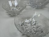 three glass bowls sitting on a table with a white table cloth