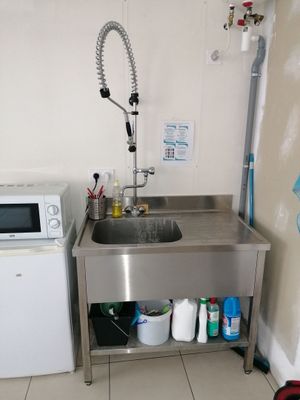 une petite cuisine équipée d'un évier et d'un lave-linge
