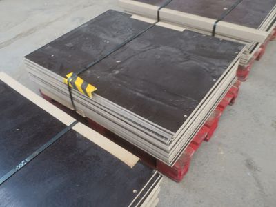 une pile de tôles d'acier posée sur des palettes dans un entrepôt