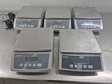four electronic scales sitting on top of a table in a room