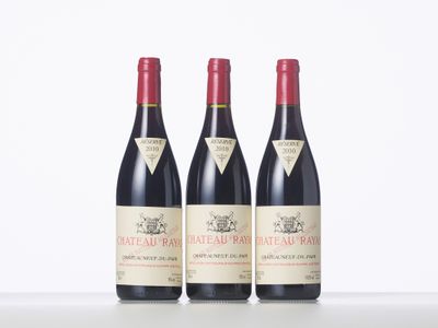 three bottles of red wine sitting on top of a table