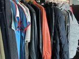 clothes hanging on a rack in front of a brick wall
