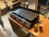 une femme debout près d'une cuisinière dans une cuisine
