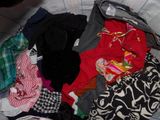 a pile of clothes sitting on top of a bed