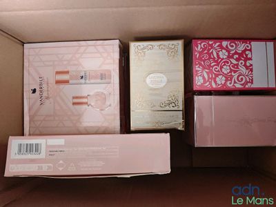 Plusieurs boîtes de produits cosmétiques sont empilées les unes sur les autres dans un carton.