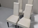 trois fauteuils en cuir blanc aux pieds noirs et un mur blanc