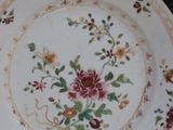 a plate with a floral design on it on a stand