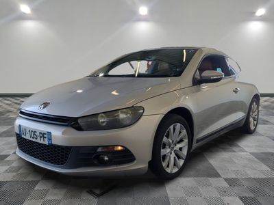 La voiture argentée est garée sur le sol à damier du showroom.
