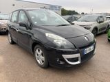 La voiture noire est garée sur un parking, avec d'autres voitures en arrière-plan.