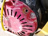 a black and pink blower sitting on the ground next to a yellow object