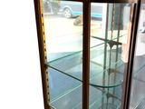 a display case with glass shelves in the corner of the room