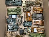 une boîte remplie de véhicules militaires miniatures et d'autres objets