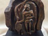 wooden sculpture of a woman sitting on a rock with a child