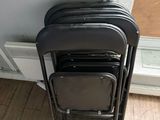 a lot of chairs that are stacked up against the wall