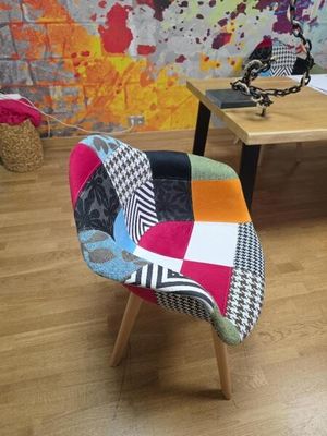 une chaise en patchwork colorée devant un mur coloré