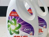 trois flacons de lessive liquide Ariel posés sur un plan de travail à côté d'un flacon de lessive en poudre