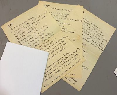 a pile of papers on a table next to a computer mouse
